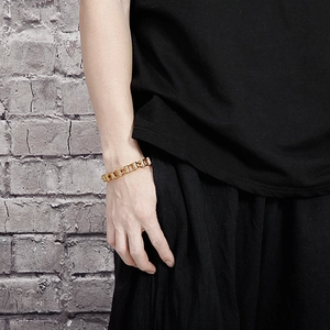 Close-up of golden stainless steel bike chain style bracelet on a man's wrist