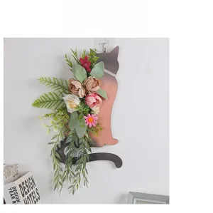 Cat silhouette wall hanging with pink roses and green plants on a white background