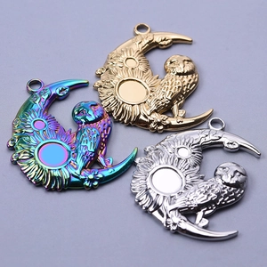 Detailed view of owl moon pendants in gold, silver, and iridescent 18k vacuum plating