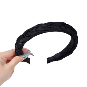 Serre-tête tressé en tissu noir à pois pour un style volumineux sur fond blanc