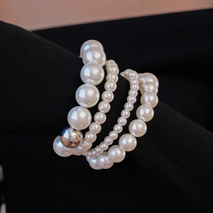 Détail macro de perles blanches multicouches avec une perle en métal argenté poli