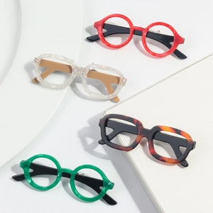 Macro shot of colorful round and square acetate doll glasses brooches on white geometry