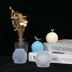 Dettaglio di stampi in silicone 3D a globo con texture in rilievo e candele in cera finite