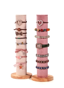 Détail de présentoirs à bijoux cylindriques en velours avec socles en bois pour chouchous
