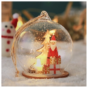 Close-up of a lit Christmas globe with Santa and wood base on a snowy backdrop
