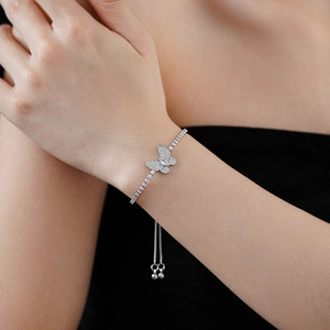 Détail du bracelet papillon ajustable avec zircons cubiques sur le poignet d'une femme