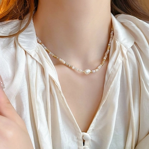 Close-up of beaded necklace with freshwater baroque pearl on model neck
