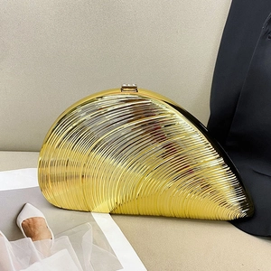 Detail of golden shell evening clutch with ribbed texture and rhinestone clasp
