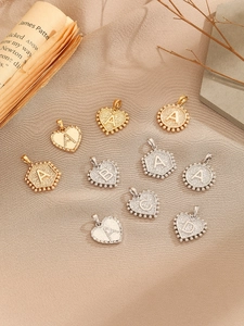 Detailed view of DIY alphabet pendants with zircon micro-paving on vintage silk fabric