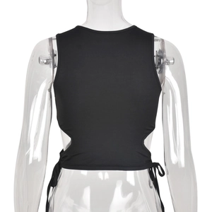 Détail du crop top noir avec découpes latérales, lacets ajustables et maille élastique