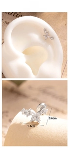 Macro detail of tiny floral and butterfly ear studs with sparkling cubic zirconia inlay