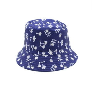 Detail of blue bucket hat with white palm tree prints and stitching on flat top