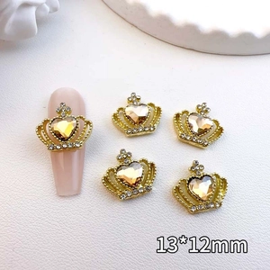 Detail view of 13x12mm gold crown nail charms with amber heart rhinestones and tiny crystals