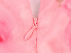 Dettaglio della cerniera invisibile su abito in chiffon rosa con trama di tessuto fine