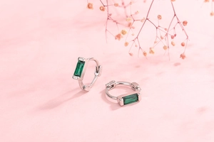 Detail shot of silver S925 earrings featuring rectangular emerald green zircon stones