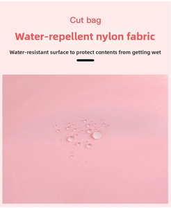 Detailed view of water-repellent pink nylon fabric showing clear water beads on surface