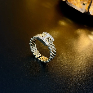 Detailed view of gold-plated H-letter ring with paved zircons and chain texture band