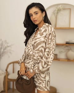 Detail of soft printed lounge set with waist tie and a woven brown handbag in interior setting