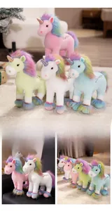 Detail view of pink unicorn plush toy showing rainbow mane and Courage embroidery