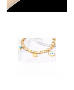 Detail eines doppellagigen Gold-Titanarmbands mit Evil Eye Anhänger und Türkis-Element