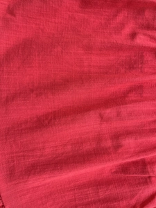 Detailed close-up of the red tiered dress fabric featuring breathable textured vertical stripes