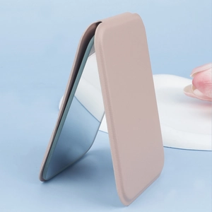 Side view of foldable pink PU leather makeup mirror standing on a white tray