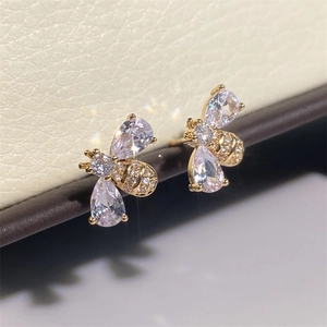 Macro shot of gold bee stud earrings featuring sparkling drop-shaped zircon wings