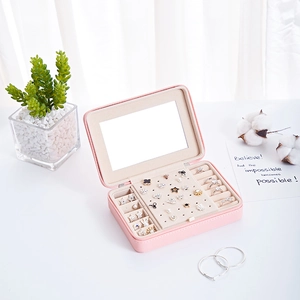 Pink portable jewelry box with mirror and storage slots for earrings and rings