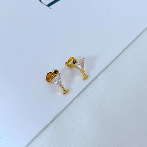 Detailed close-up of golden cocktail glass stud earrings with zircon inlay design