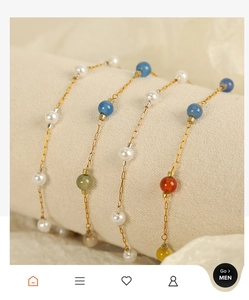 Macro shot of colorful beaded bracelets with gold chain and white pearls on a soft stand