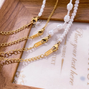 Detail of 18K gold lobster clasp with K18 engraving on irregular baroque pearl necklace
