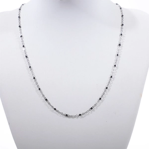 Elegant stainless steel necklace with black bead accents on a white model bust