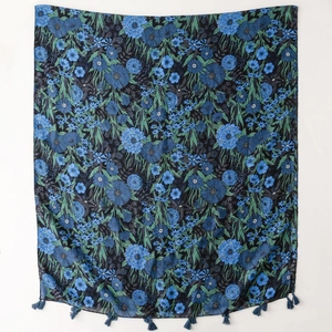 Detail of dark blue floral print scarf featuring elegant tassels and soft fabric texture