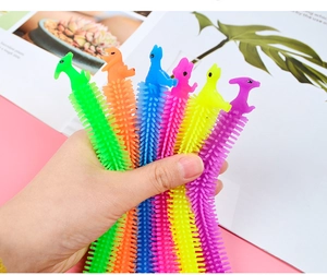 Close-up of six colorful textured TPR dinosaur sensory fidget strings held in hand