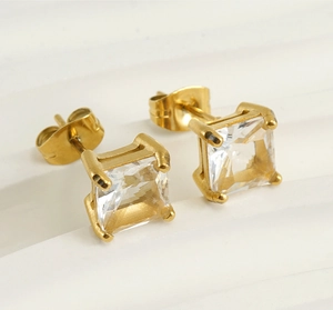 Macro view of gold stainless steel stud earrings featuring square-cut clear zircon stones