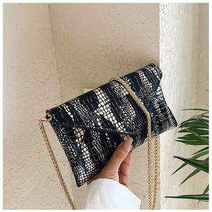 Detail of the crocodile pattern envelope bag with a detachable gold chain shoulder strap