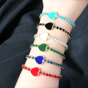 Detailed view of colorful heart-shaped zircon tennis bracelets on a woman's wrist