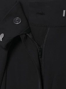 Detail of black trousers showing secure triple closure with button, zipper, and metal hook