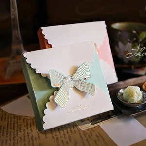 Close-up of pastel mint and pink gift boxes with golden bow and Thank You gold foil text