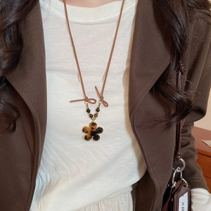 Close-up of leopard pattern flower pendant necklace with resin texture and brown cord
