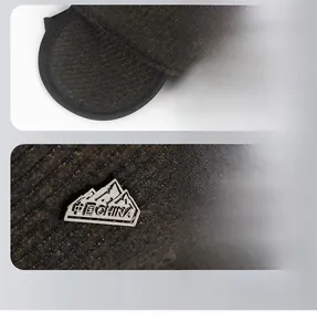 Detail of winter baseball hat featuring foldable ear flaps and a metal mountain emblem