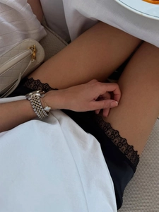Detail of elegant black satin skirt hem with delicate lace trim and luxury styling