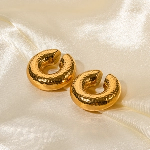 Detailed view of 18K gold plated textured thick hoop earrings on soft silk fabric