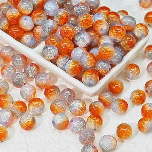 Macro shot of 10mm cracked aurora glass beads in orange and purple for DIY jewelry making