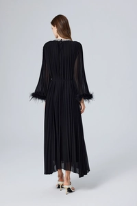 Gros plan sur les plis et les poignets en plumes du dos de la robe noire élégante