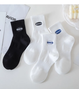 Detail view of cotton athletic crew socks with custom MOMOGN embroidery in black and white