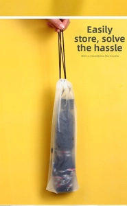 Nahaufnahme der mattierten Kordelzugtasche mit einem dunkel karierten Klappschirm