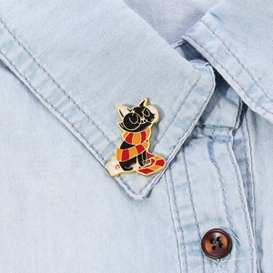 Cute black cat enamel pin wearing a striped scarf on a white envelope for denim jackets
