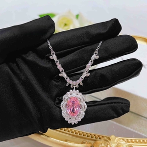 Macro view of luxurious pink oval gemstone necklace with sparkling diamond halo setting