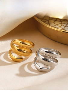 Detail of minimalist gold and silver spiral rings featuring a layered chunky design